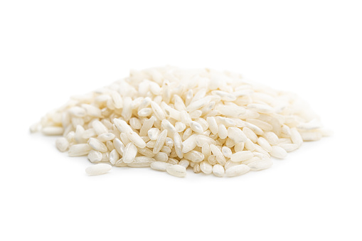 Uncooked Carnaroli risotto rice isolated on a white background.