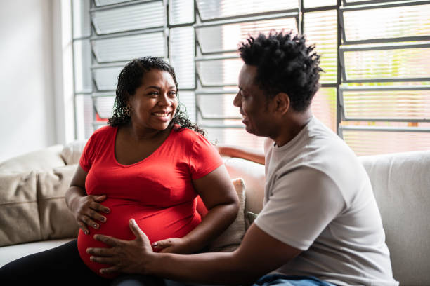 istock Husband touching pregnant wife's abdomen at home 1390901049