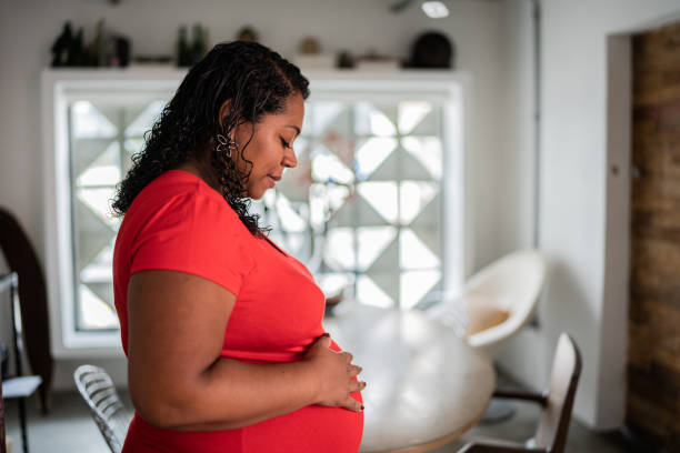 femme enceinte se relaxant à la maison - healthcare and medicine home interior side view vertical photos et images de collection