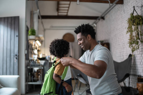 istock Father helping son with backpack at home before leaving to school 1390901285
