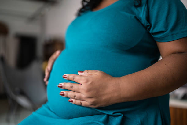 istock Pregnant woman touching her belly 1390901616