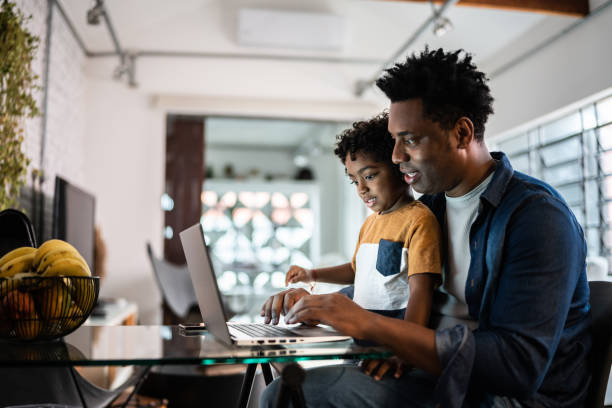 istock Father using the laptop with son at home 1390901747