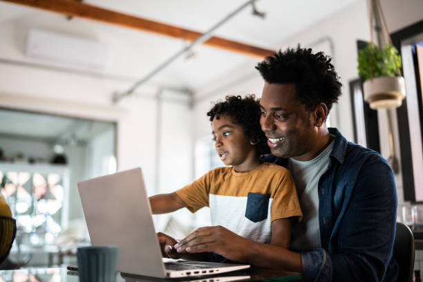 istock Father using the laptop with son at home 1390901768