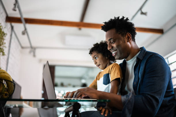 istock Father using the laptop with son at home 1390901773