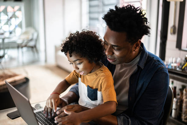 istock Father using the laptop with son at home 1390901774