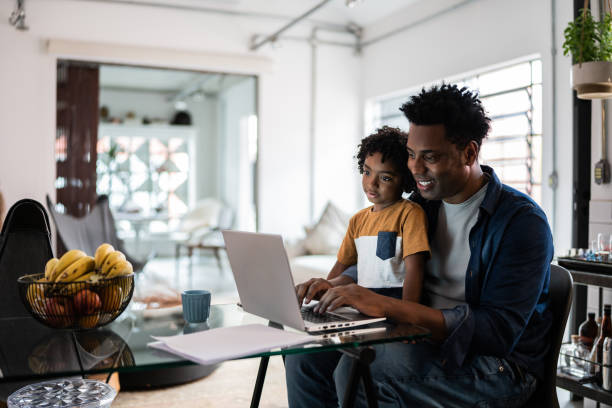 istock Father using the laptop with son at home 1390901788