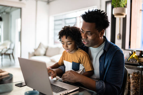 istock Father using the laptop with son at home 1390901789