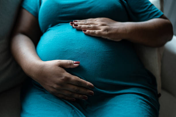 pregnant woman touching her belly - anticipation built structure indoors image technique fotografías e imágenes de stock