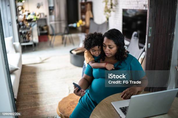 Pregnant Woman Using Laptop At Home With Son Stock Photo - Download Image Now - Pregnant, Mother, Child