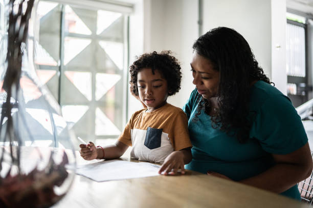 istock Mother helping son drawing or writing at home 1390902749
