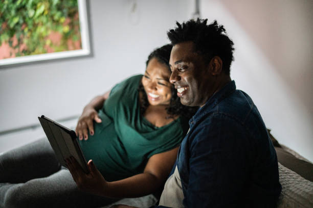 istock Happy pregnant couple using digital tablet on the bed at home 1390902872