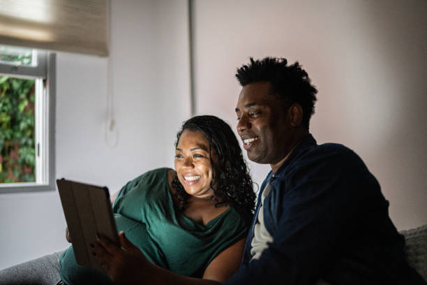 istock Happy pregnant couple using digital tablet on the bed at home 1390902888
