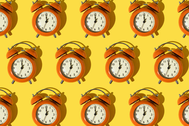 istock Pattern made of red retro clocks on yellow background. 1390902999