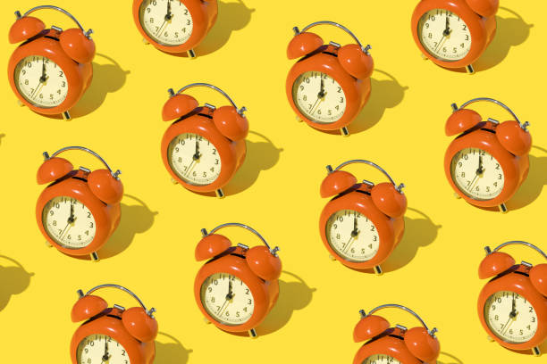 istock Pattern made of red retro clocks on yellow background. 1390903013