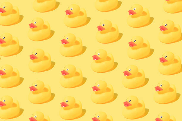 istock Pattern made of rubber bath ducks on yellow background. 1390903058