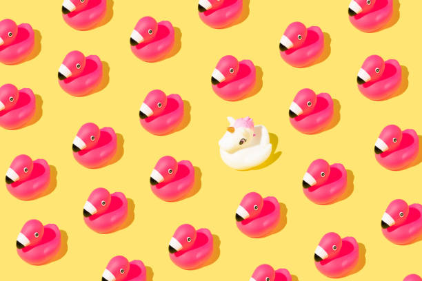 istock Summer pattern with rubber pink flamingos and a unicorn on yellow background. 1390903069