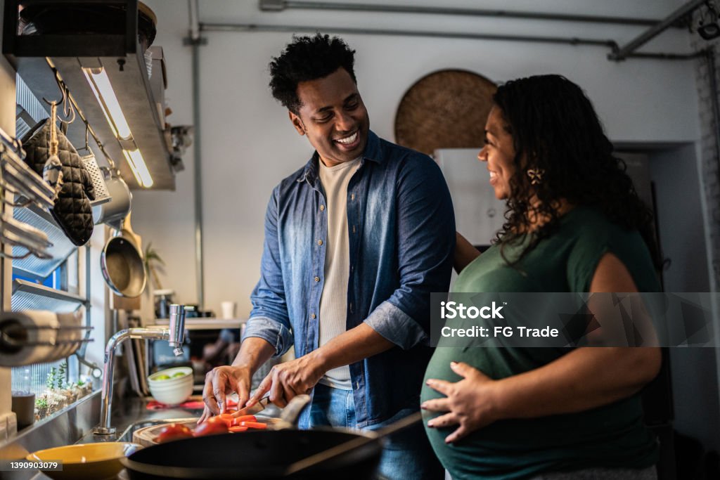 Couple cooking together at home Pregnant Stock Photo
