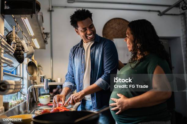 Couple Cooking Together At Home Stock Photo - Download Image Now - Pregnant, Cooking, Family