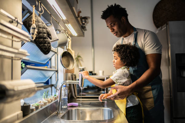 istock Father and son washing dishes at home 1390903134