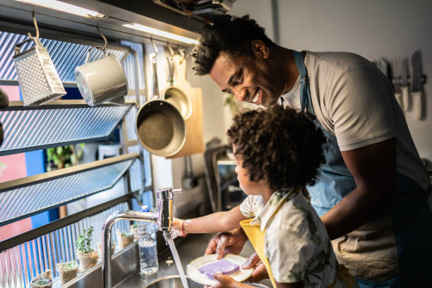 istock Father and son washing dishes at home 1390903141