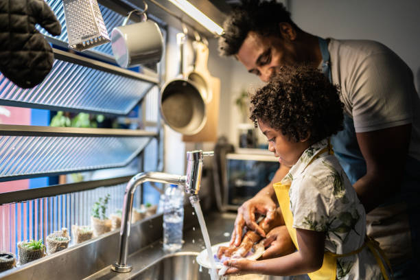 istock Father and son washing dishes at home 1390903149