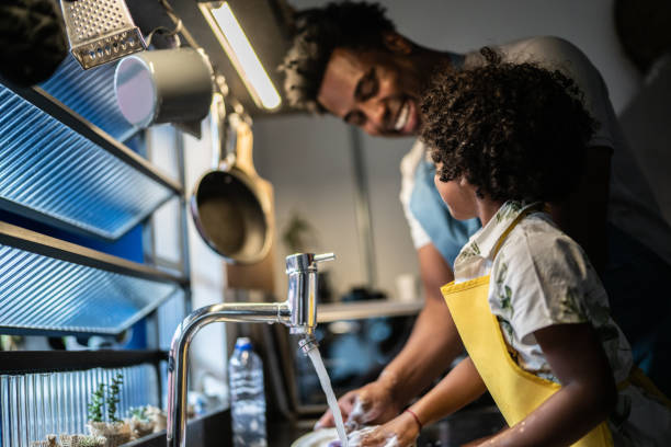 istock Father and son washing dishes at home 1390903167