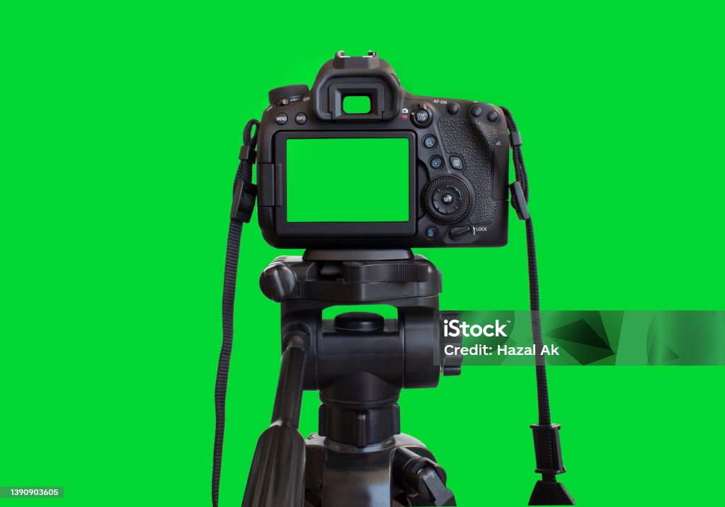 Dslr camera with empty screen on the tripod, isolated on green background. Green screen camera. Camera - Photographic Equipment Stock Photo