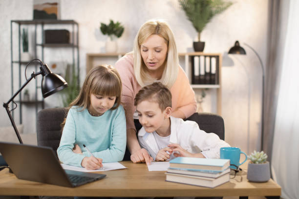 istock Mother teach young son and daughter homework, using digital laptop at home. 1390903633