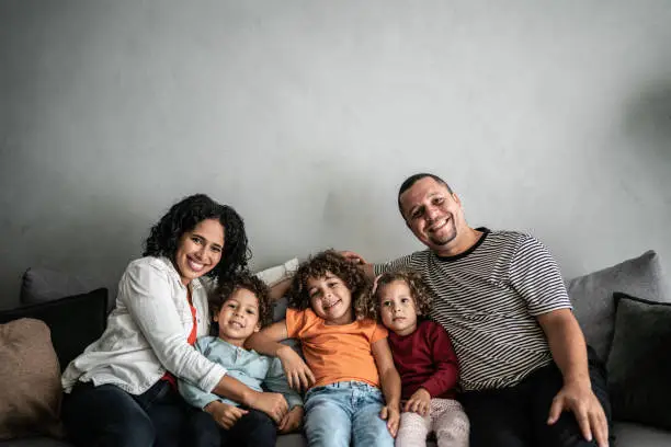 Photo of Portrait of a family sitting on the sofa at home