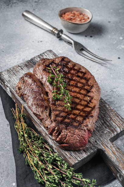 arrostito sulla bistecca di controfiletto superiore alla griglia con rosmarino e timo. sfondo grigio. vista dall'alto - picanha beef meat rare foto e immagini stock