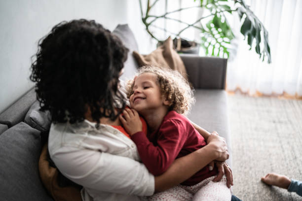 istock Daughter sitting on mother's lap at home 1390905021