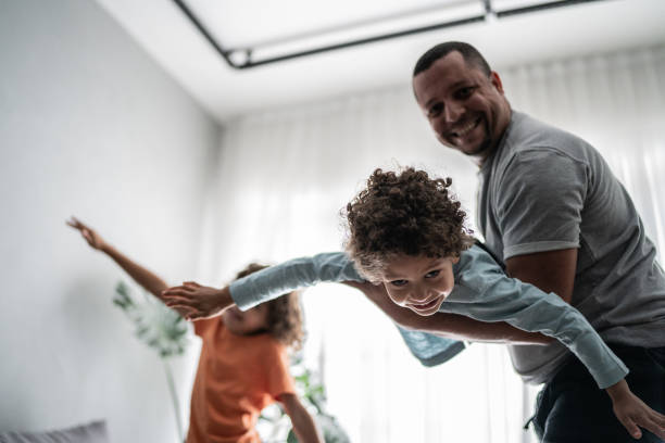 istock Father playing with sons at home 1390905137