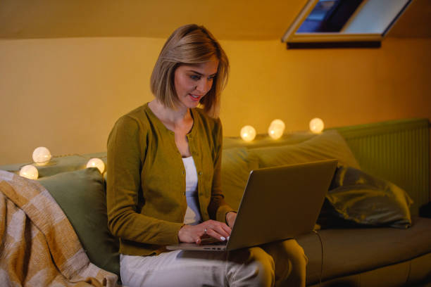 istock Woman typing emails or data on laptop while lounging on the sofa 1390905791