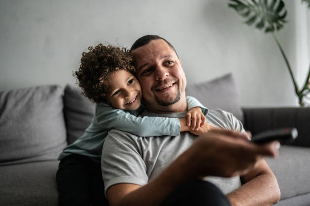 istock Father and son watching TV at home 1390905974