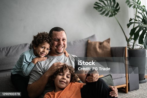 istock Father and sons watching TV at home 1390905978