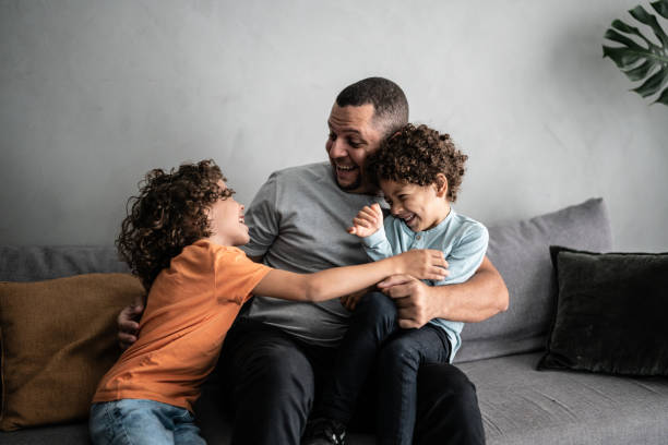 istock Father playing tickling with sons at home 1390906086