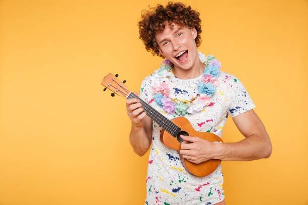 istock Attractive young man in summer clothes playing ukulele 1390906256