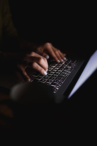 istock Unrecognizable woman typing on keyboard while using laptop late at night 1390906292
