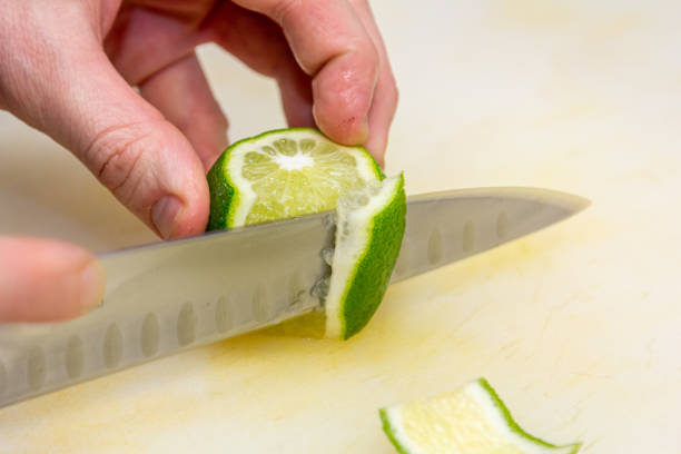 istock The chef cuts the skin from the lime with a knife on a white board 1390906412
