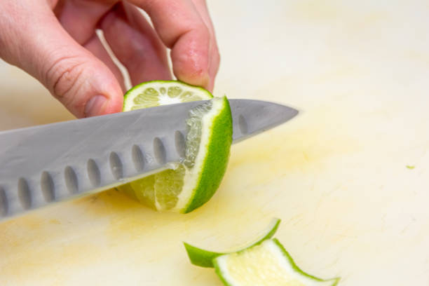 istock The chef cuts the skin from the lime with a knife on a white board 1390906417
