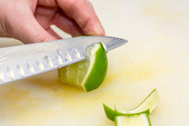 istock The chef cuts the skin from the lime with a knife on a white board 1390906439