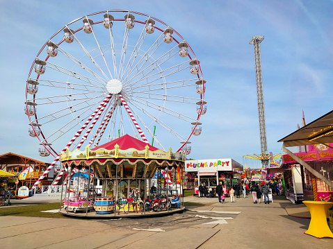 The Hague, Netherlands - April 2022: Circus with caroussel and large Ferris Wheel in city park Malieveld in the city of The Hague, The Netherlands.