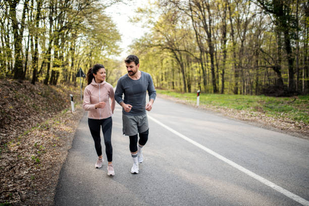 istock Happy athletic couple having fun while running in spring day 1390908595