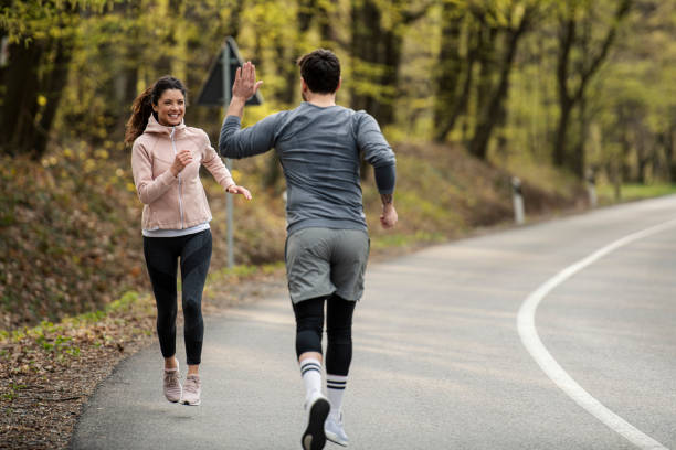istock Happy athletic couple having fun while running in spring day 1390908606