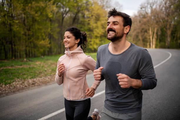 istock Happy athletic couple having fun while running in spring day 1390908644