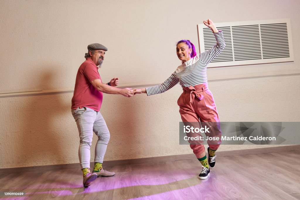 A senior adult couple dancing Lindy Hop in a studio A senior adult couple dancing Lindy Hop in a studio wearing funny socks and old fashioned clothing Swing Dancing Stock Photo