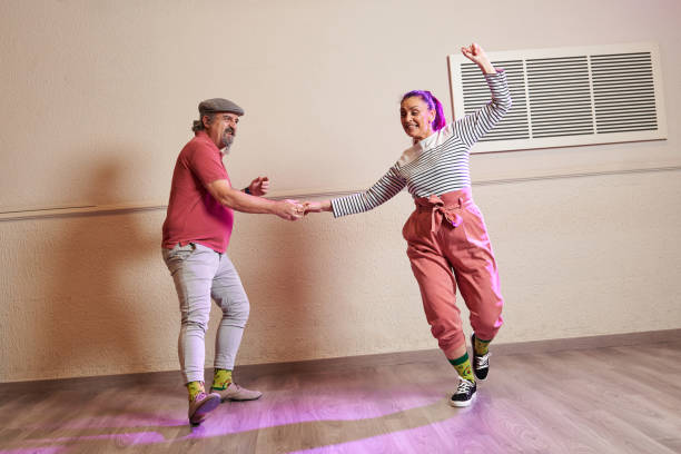 A senior adult couple dancing Lindy Hop in a studio A senior adult couple dancing Lindy Hop in a studio wearing funny socks and old fashioned clothing boogie woogie dancing stock pictures, royalty-free photos & images