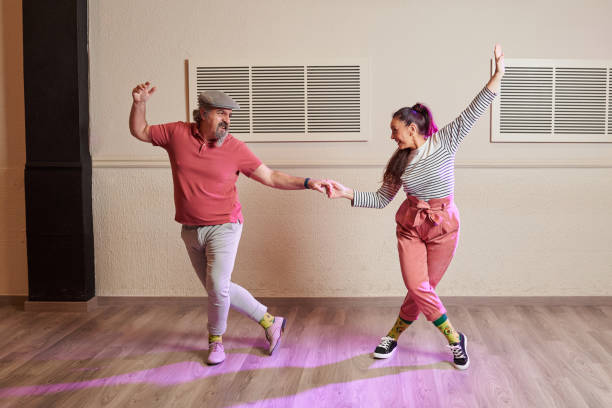 A senior adult couple dancing Lindy Hop in a studio A senior adult couple dancing Lindy Hop in a studio wearing funny socks and old fashioned clothing lindy hop stock pictures, royalty-free photos & images