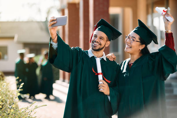 istock Happy graduate students having fun and taking selfie after graduation ceremony. 1390915309