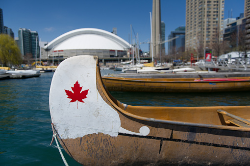 Maple Leaf on a canoe at the Toronto Marina. In background buildings of the downtown core.